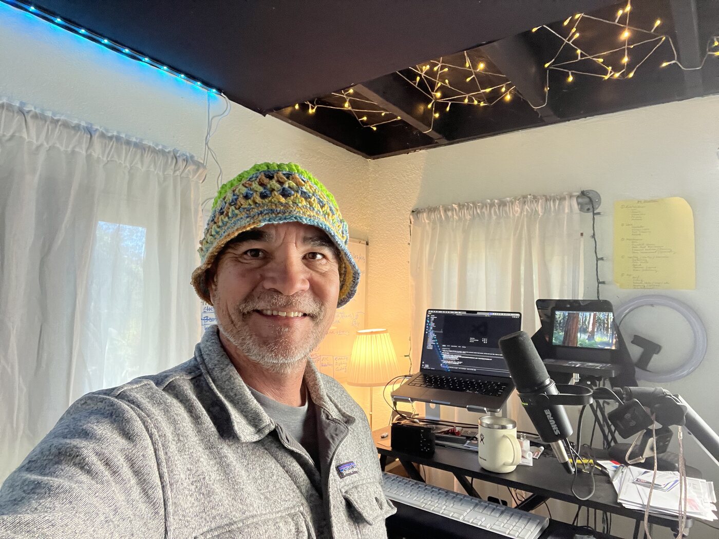 A blue, green and gold summer hat, worn at a desk